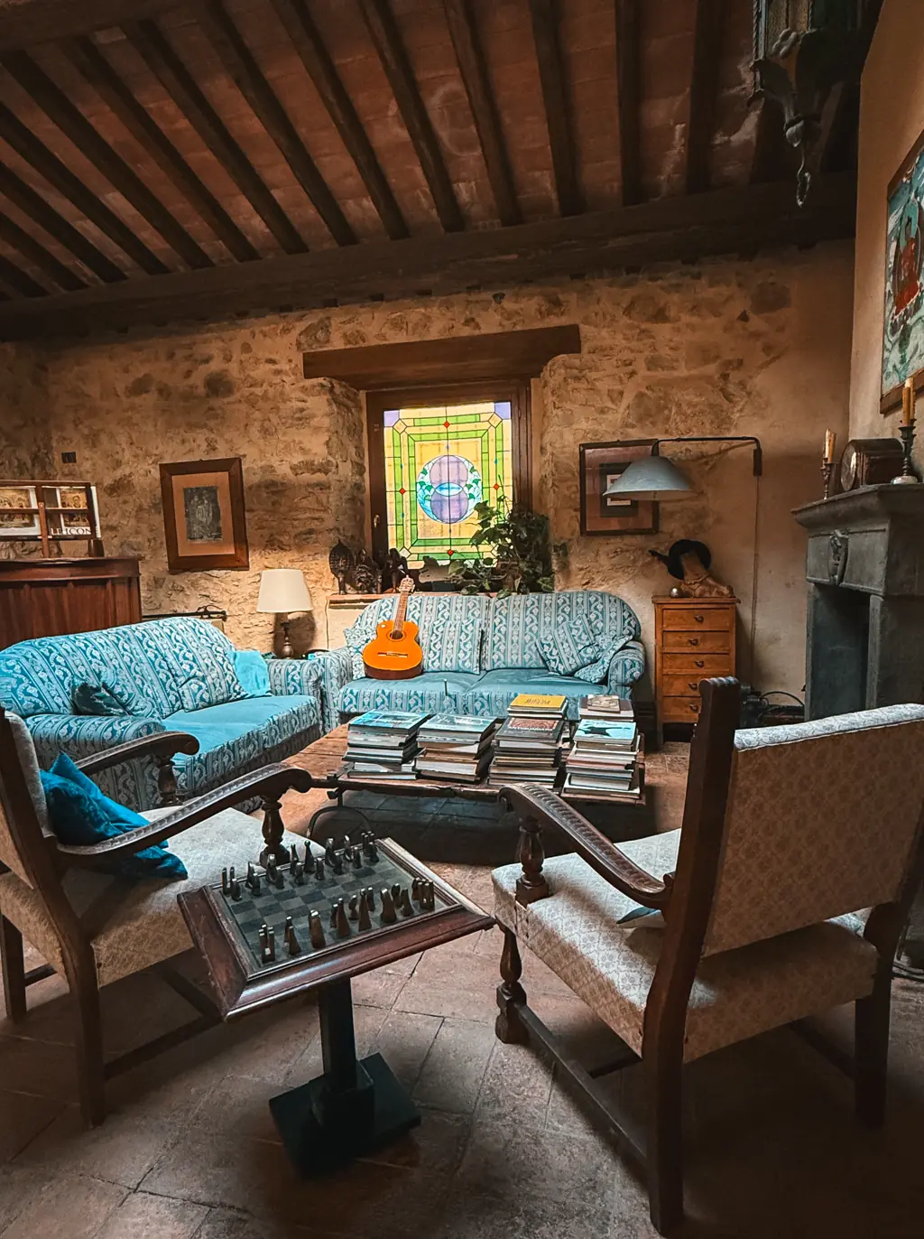 Il salone del Casale: divani, camino e vetrata colorata